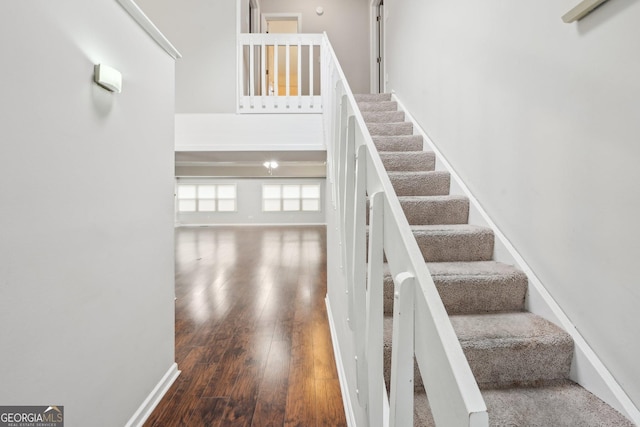 stairway featuring baseboards and wood finished floors