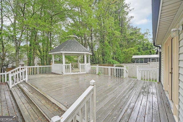 wooden deck with a gazebo and fence