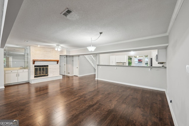 unfurnished living room featuring visible vents, a textured ceiling, baseboards, and ceiling fan