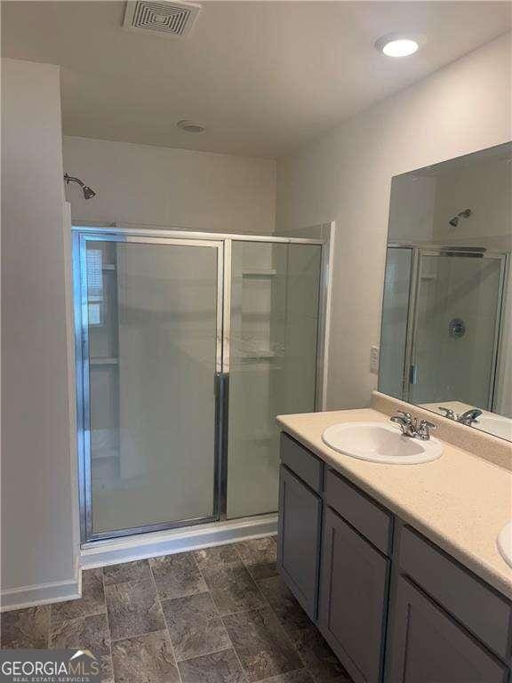 184 Grafton St, Hampton, GA 30228 - full bathroom with double vanity, visible vents, a sink, and a stall shower