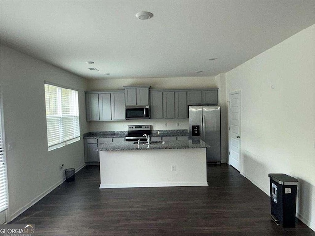 184 Grafton St, Hampton, GA 30228 - kitchen with dark wood-style flooring, gray cabinetry, a kitchen island with sink, appliances with stainless steel finishes, and a sink