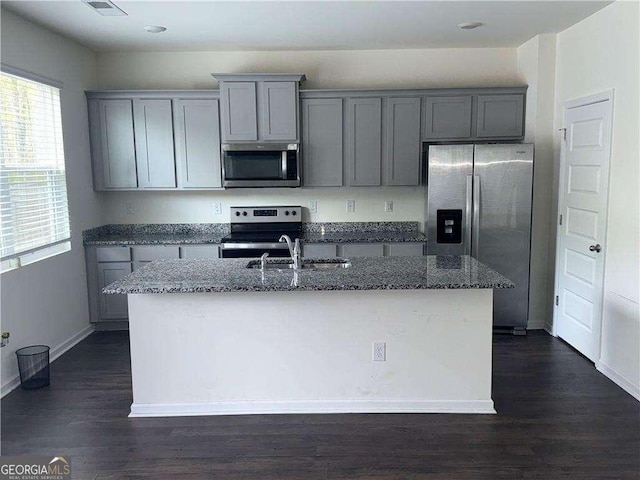 184 Grafton St, Hampton, GA 30228 - kitchen with dark wood-style flooring, gray cabinetry, a center island with sink, stone counters, and stainless steel appliances