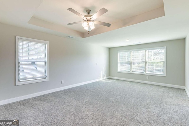 417 Flowery Branch Ct, Villa Rica, GA 30180 - unfurnished room with visible vents, baseboards, ceiling fan, a tray ceiling, and carpet floors