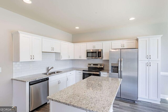 417 Flowery Branch Ct, Villa Rica, GA 30180 - kitchen with white cabinets, a kitchen island, appliances with stainless steel finishes, wood finished floors, and a sink