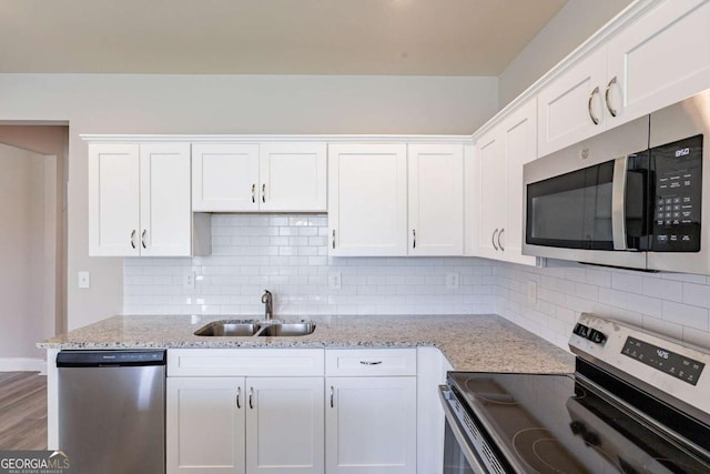417 Flowery Branch Ct, Villa Rica, GA 30180 - kitchen featuring a sink, white cabinetry, stainless steel appliances, backsplash, and light stone counters