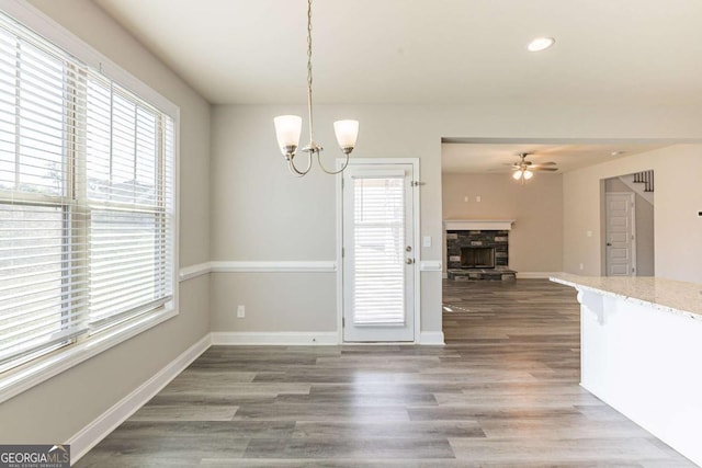 417 Flowery Branch Ct, Villa Rica, GA 30180 - unfurnished dining area with a stone fireplace, baseboards, recessed lighting, ceiling fan with notable chandelier, and wood finished floors