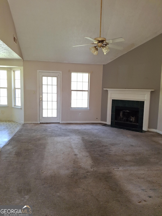 172 Willow Springs Ln, Stockbridge, GA 30281 - unfurnished living room with lofted ceiling, ceiling fan, a tile fireplace, and carpet floors