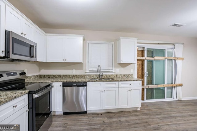 4094 E Glade Ct, Decatur, GA 30035 - kitchen with light wood-style flooring, white cabinets, visible vents, appliances with stainless steel finishes, and a sink