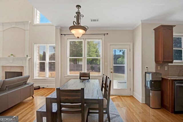 5177 Cabot Creek Dr, Buford, GA 30518 - dining space featuring healthy amount of natural light, light wood finished floors, crown molding, and a tiled fireplace