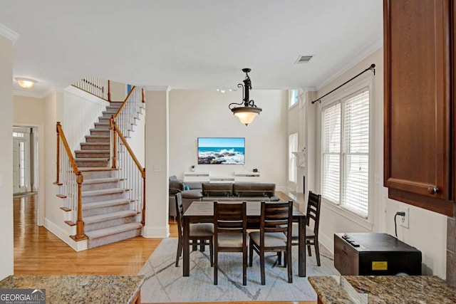 5177 Cabot Creek Dr, Buford, GA 30518 - dining space featuring ornamental molding, healthy amount of natural light, stairs, and light wood finished floors