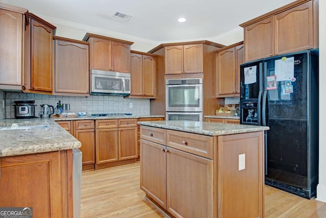 5177 Cabot Creek Dr, Buford, GA 30518 - kitchen featuring stainless steel appliances, crown molding, light wood-style floors, a center island, and light stone counters