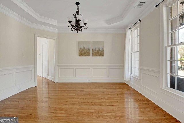 5177 Cabot Creek Dr, Buford, GA 30518 - unfurnished dining area featuring a chandelier, light wood-type flooring, a tray ceiling, ornamental molding, and wainscoting