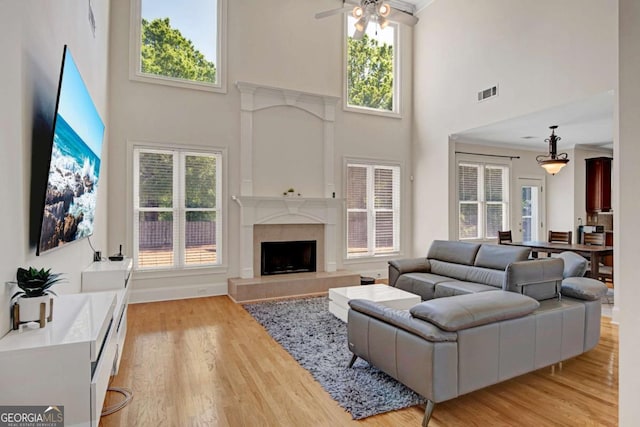 5177 Cabot Creek Dr, Buford, GA 30518 - living room with a high ceiling, a fireplace with raised hearth, plenty of natural light, ceiling fan, and light wood finished floors