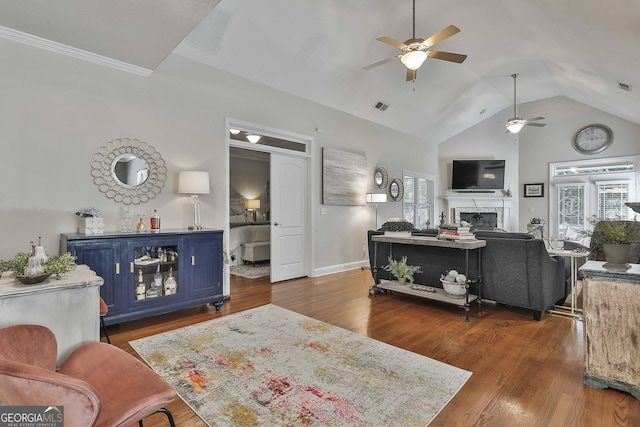 living room featuring a fireplace, visible vents, wood finished floors, and ceiling fan