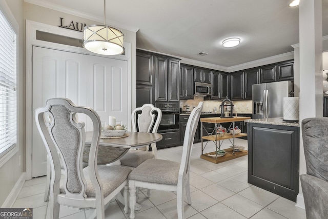 kitchen featuring tasteful backsplash, ornamental molding, dark cabinetry, and appliances with stainless steel finishes