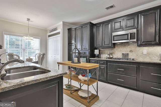 kitchen featuring stainless steel microwave, light tile patterned flooring, visible vents, gas stovetop, and a sink
