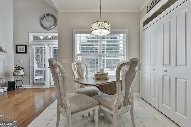 dining room with crown molding, light tile patterned floors, and baseboards