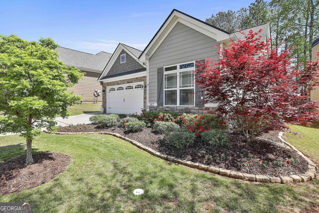 view of front of property featuring a garage, driveway, stone siding, and a front lawn
