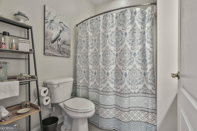 bathroom featuring toilet and a shower with curtain