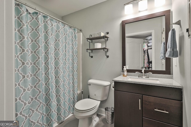 bathroom with toilet, curtained shower, vanity, and baseboards