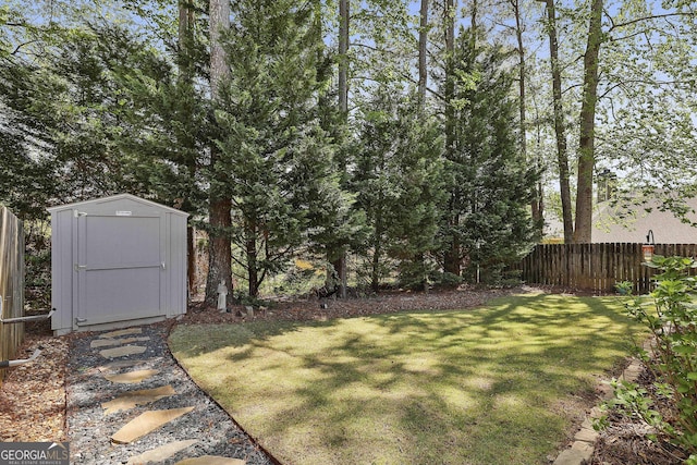 view of yard with a storage shed, fence, and an outbuilding