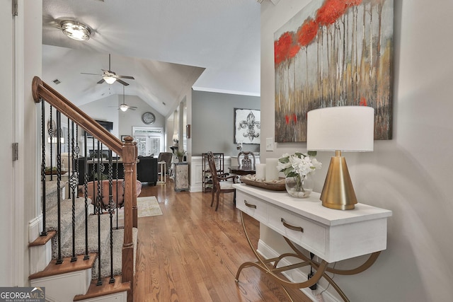 entrance foyer featuring ceiling fan, visible vents, wood finished floors, lofted ceiling, and stairs