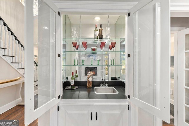 indoor wet bar with stairs and wood finished floors