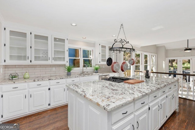 kitchen featuring a sink, a center island, gas stovetop, dark wood finished floors, and recessed lighting