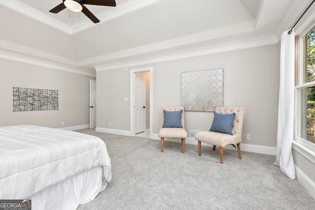 carpeted bedroom featuring a tray ceiling, ornamental molding, baseboards, and ceiling fan