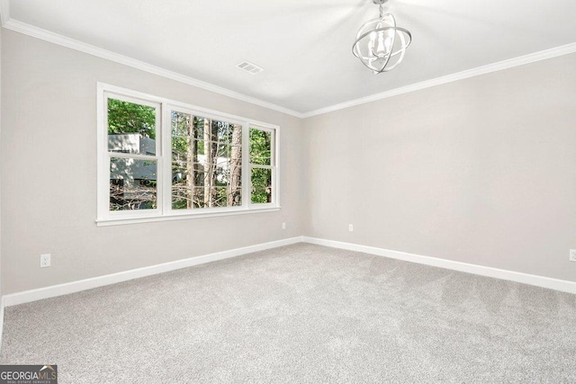 carpeted empty room with ornamental molding and baseboards