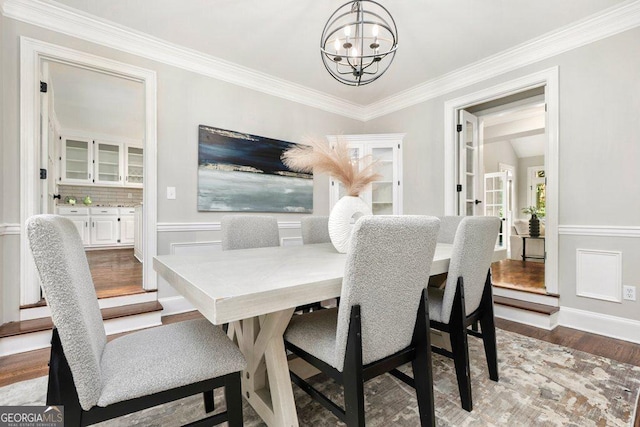 dining area featuring a chandelier, wood finished floors, and ornamental molding