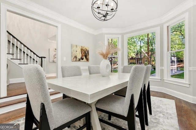 dining area with healthy amount of natural light, a chandelier, baseboards, dark wood-type flooring, and ornamental molding