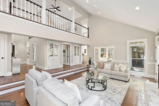 living area featuring wood finished floors, high vaulted ceiling, recessed lighting, ceiling fan, and baseboards