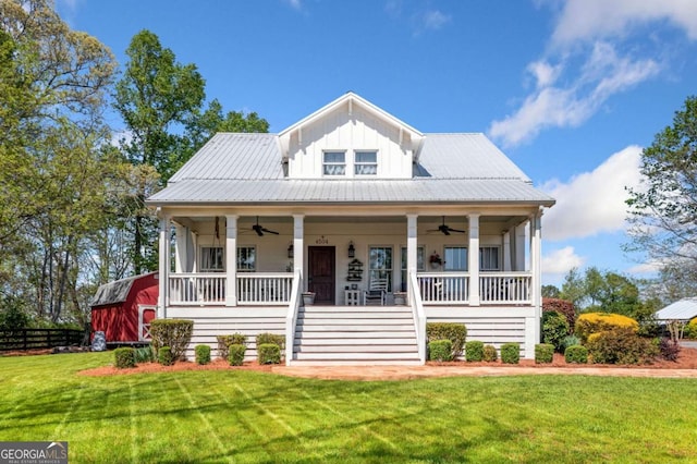 view of front of home with covered porch, ceiling fan, fence, and a front lawn