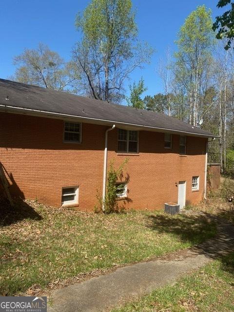 view of home's exterior with a lawn and brick siding