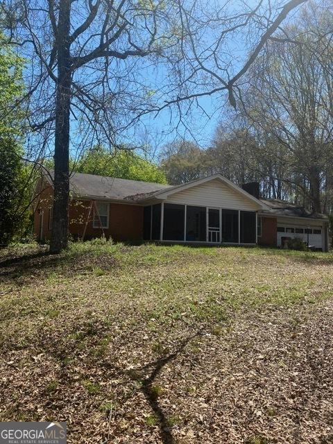 rear view of house featuring a sunroom