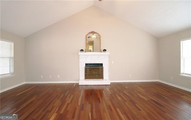 unfurnished living room featuring lofted ceiling, wood finished floors, and a healthy amount of sunlight
