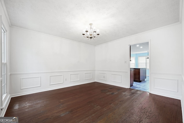 985 Lake Haven Ct, Roswell, GA 30076 - unfurnished dining area with a chandelier, a textured ceiling, crown molding, and dark wood finished floors