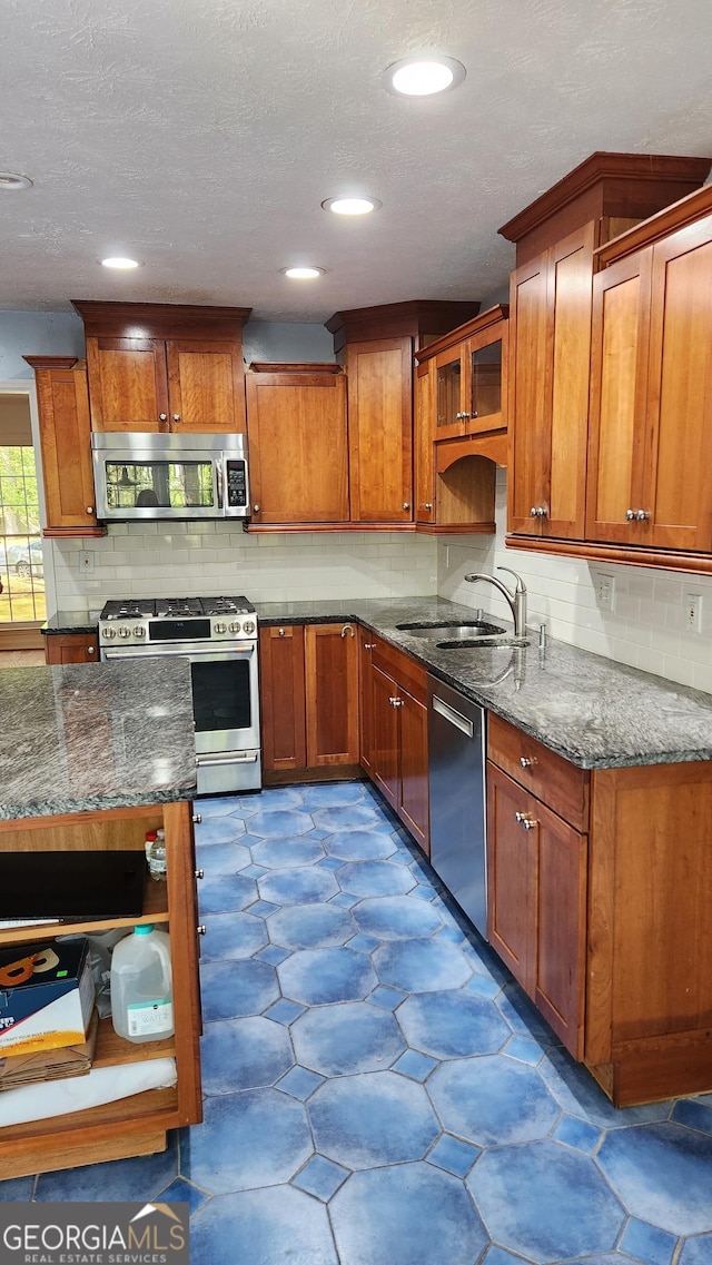 985 Lake Haven Ct, Roswell, GA 30076 - kitchen with dark stone counters, tasteful backsplash, a sink, stainless steel appliances, and brown cabinets