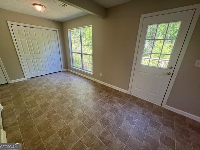 interior space featuring a healthy amount of sunlight, baseboards, and visible vents