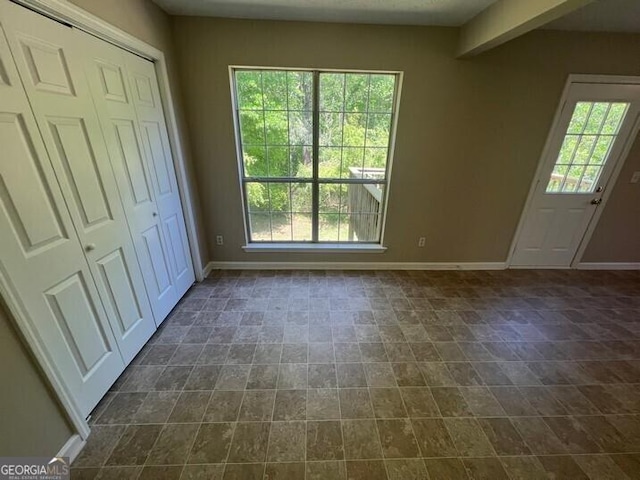 unfurnished bedroom with baseboards and a closet