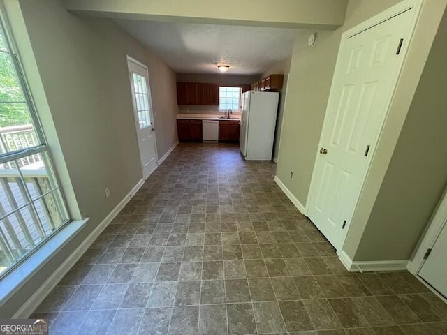 hall with baseboards and a sink