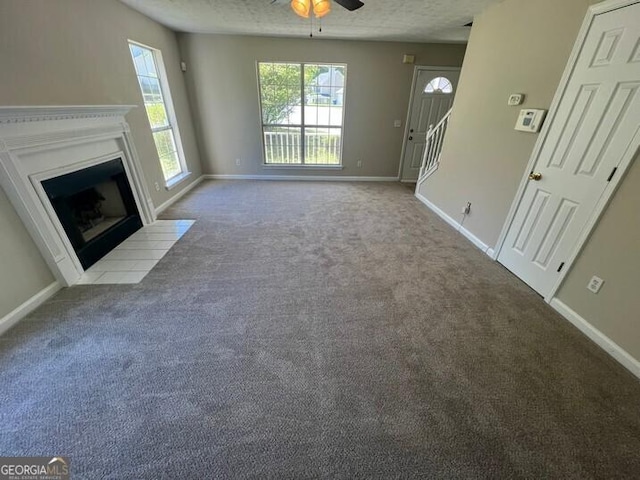 unfurnished living room with carpet floors, a healthy amount of sunlight, and ceiling fan