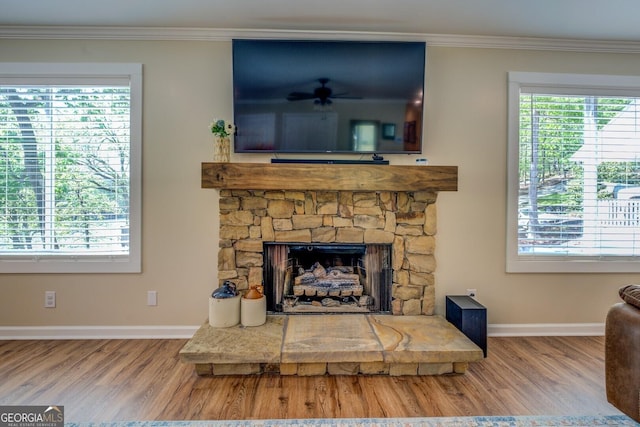 living area with baseboards, crown molding, and wood finished floors