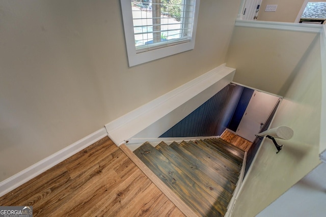 staircase featuring baseboards and wood finished floors