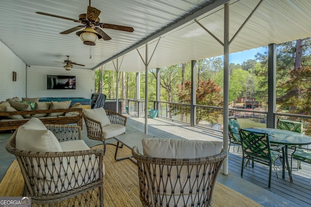 sunroom featuring ceiling fan, outdoor lounge area, and outdoor dining space