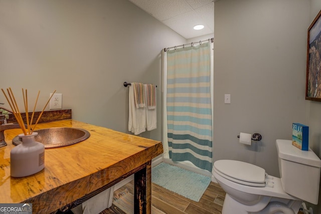 bathroom with baseboards, wood finished floors, a shower with shower curtain, and toilet