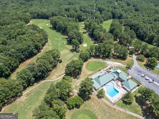 aerial view with golf course view and a forest view