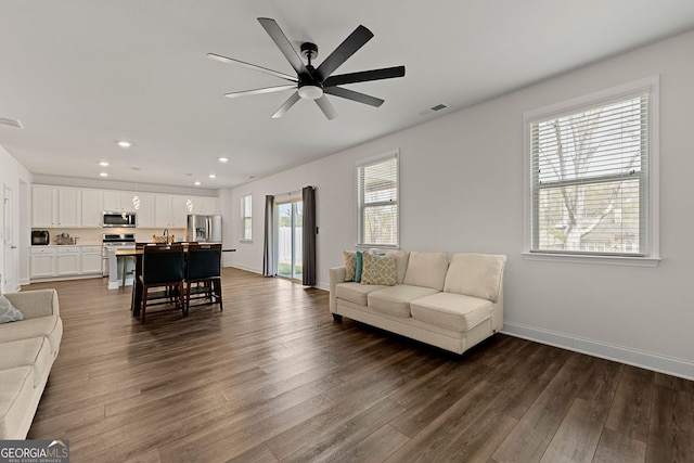 living room with dark wood-style floors, a ceiling fan, visible vents, and recessed lighting