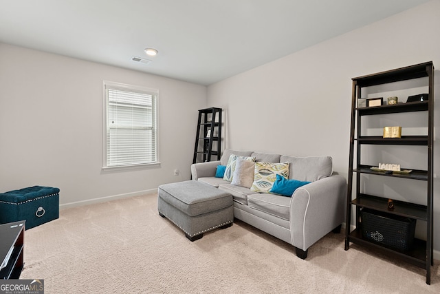 carpeted living area featuring visible vents and baseboards